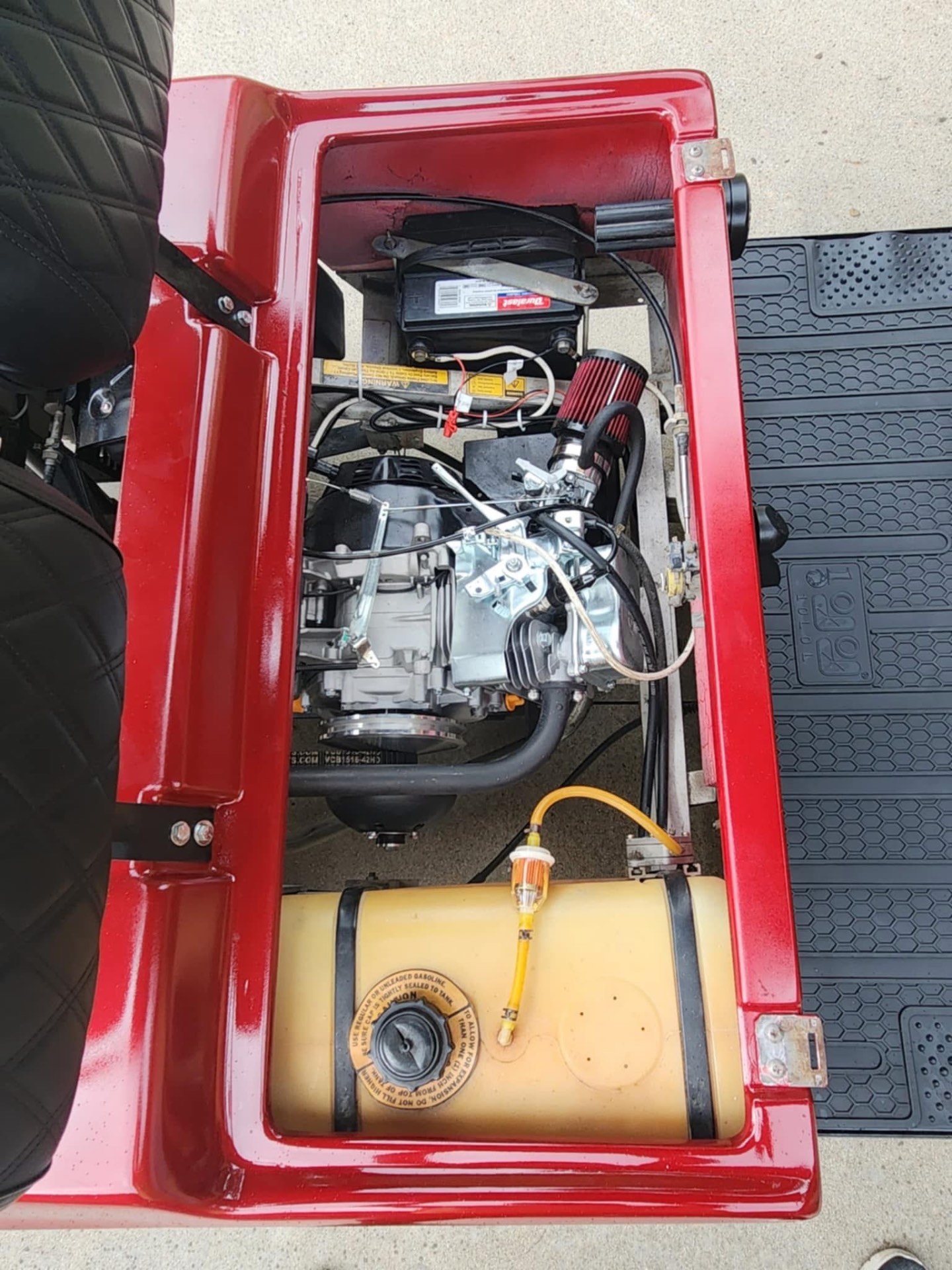 Predator engine swap inside a red Club Car